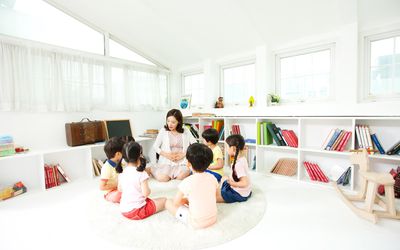 group of young children circled around teacher on the floor