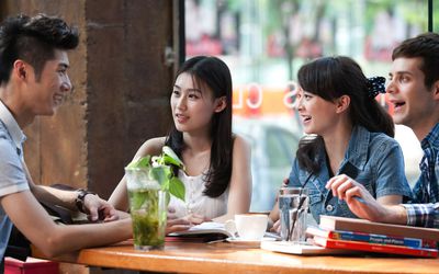 young men and women having conversation at cafe