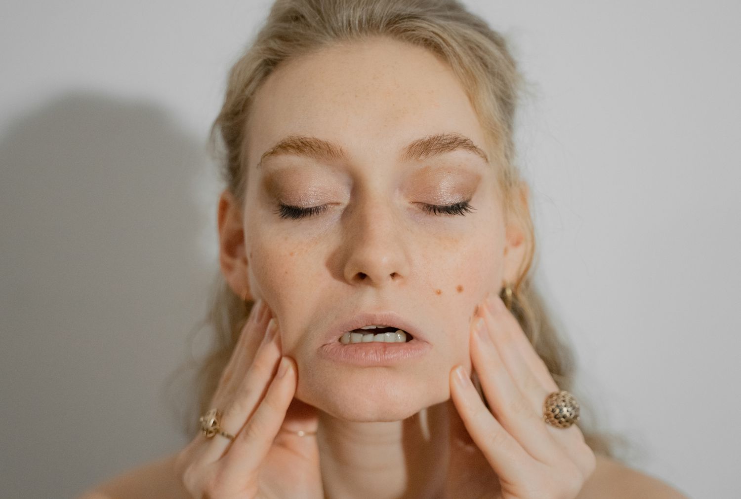 Femme pratiquant des exercices de yoga du visage pour des bienfaits pour la santé. Elle étire ses joues.